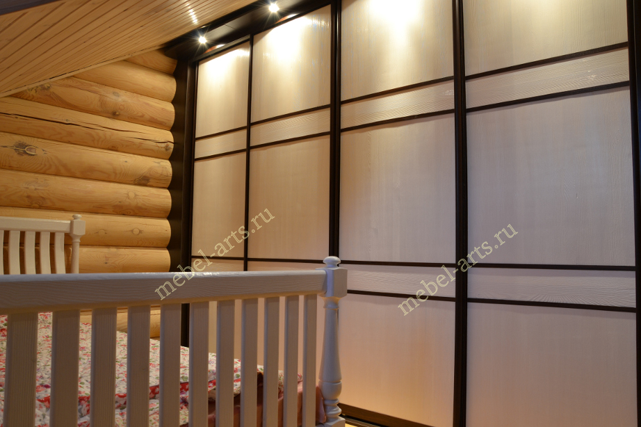 Кровать в интерьере спальни дома из оцилиндрованного бревна